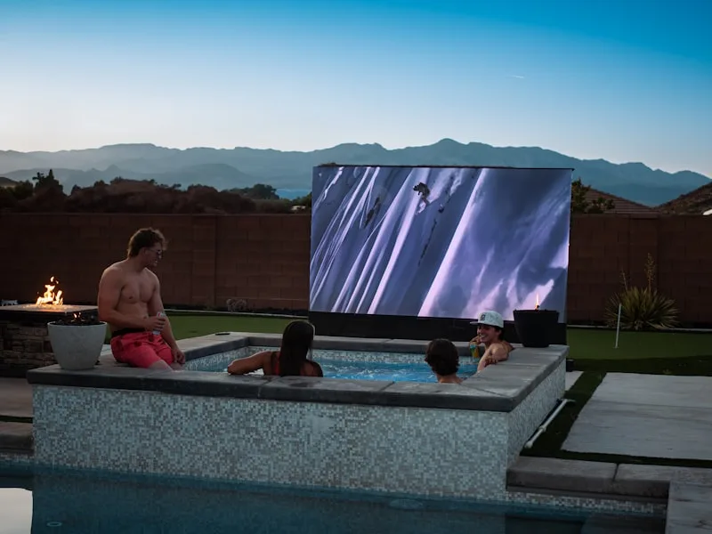 Friends enjoying a large outdoor hot tub in the evening